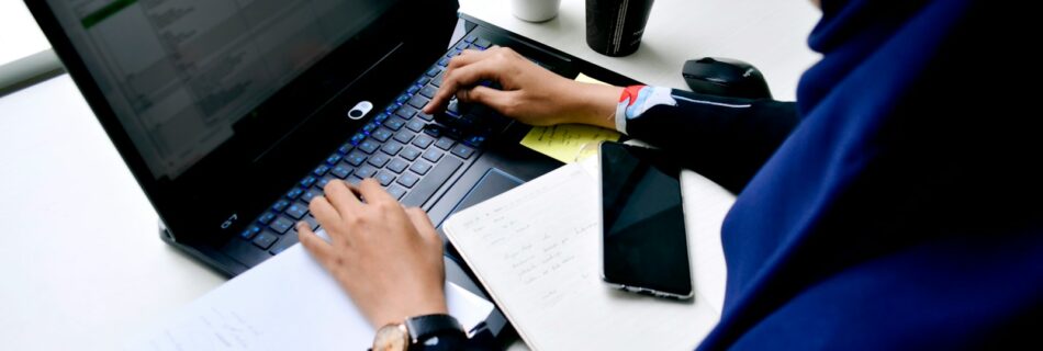 person in blue long sleeve shirt using black laptop computer