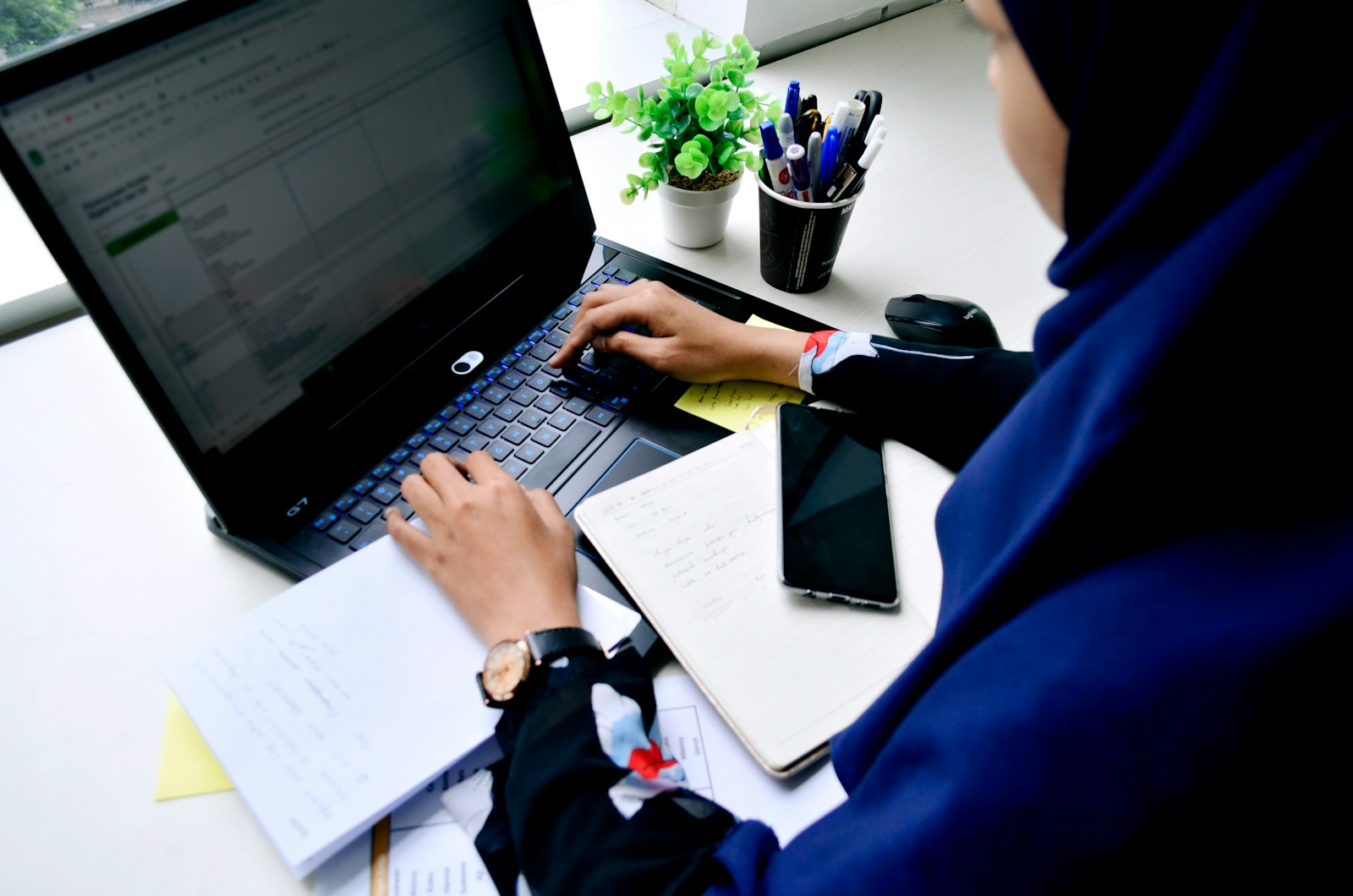 person in blue long sleeve shirt using black laptop computer