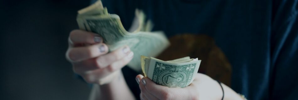 focus photography of person counting dollar banknotes