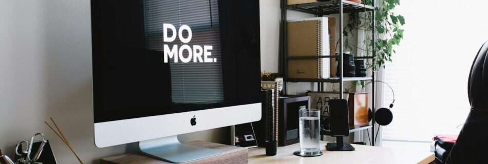 silver iMac with keyboard and trackpad inside room