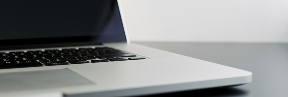 silver laptop computer on black table