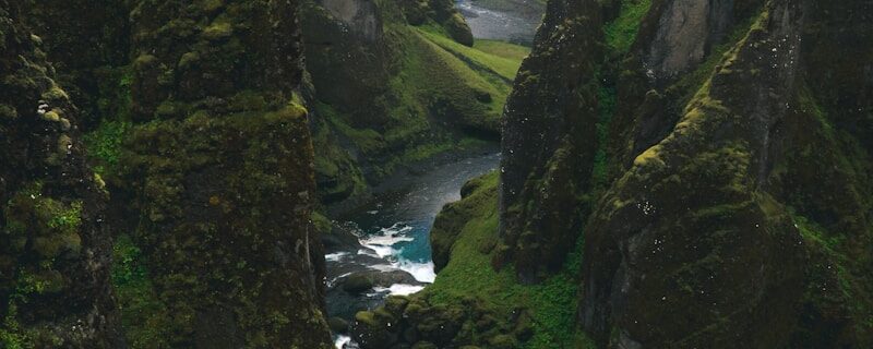 aerial view photography of body of water across green mountains